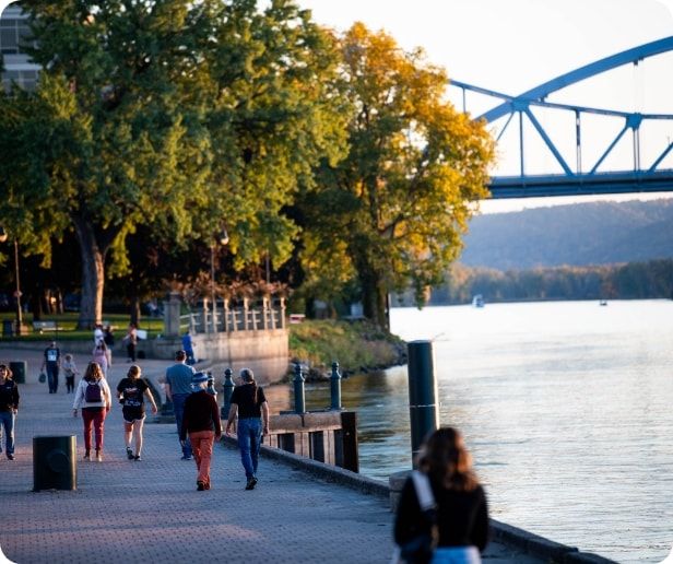 People walking on a path alongside the Mississippi River.  