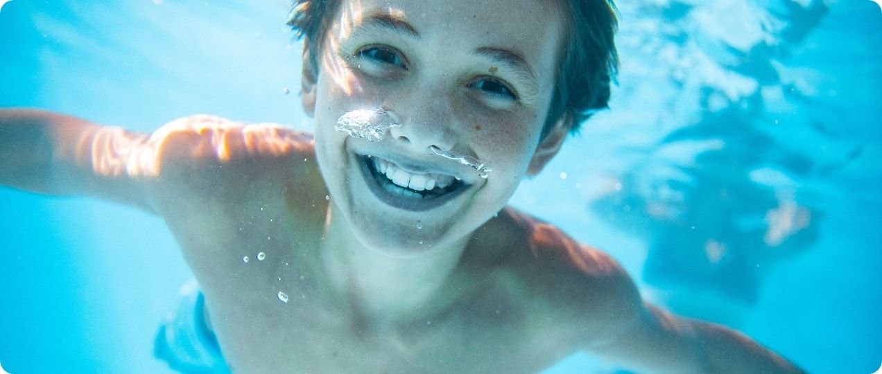 A kid smiling underwater. 
