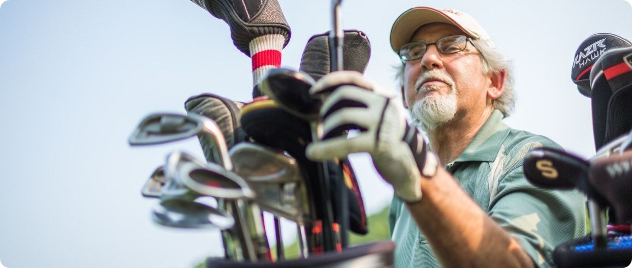 A golfer selects his golf club for his next shot.